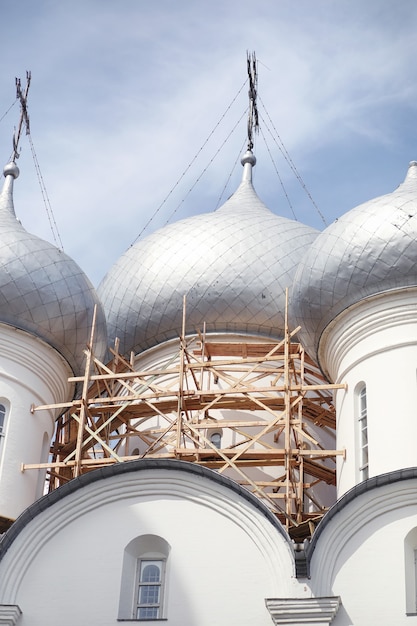 Купола культового сооружения. Кресты на куполах церкви. Собор с серебряными куполами на фоне неба