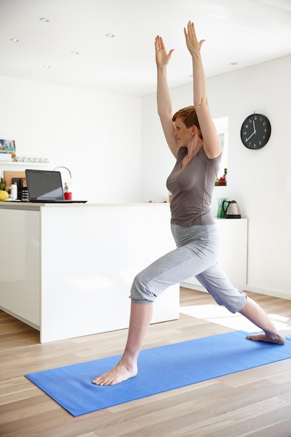 Domestic warrior Shot of an attractive woman doing yoga in her home