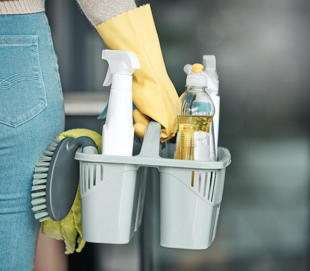 家事労働者のメイドまたはクリーナーの手が、掃除用の製品および機器または消耗品を持っているか、運んでいます。