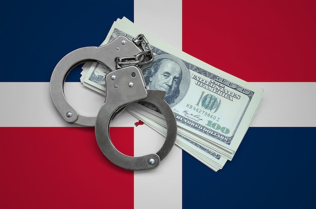 Флаг Доминиканской Республики с наручниками и пачкой долларов. Валютная коррупция в стране. Финансовые преступления
