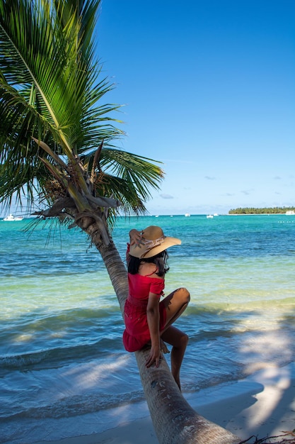 Dominican Republic of Punta Cana a girl in a hat on the ocean with turquoise water and palm trees