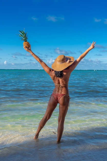 Доминиканская Республика Пунта-Кана девушка в шляпе на берегу океана с бирюзовой водой и пальмами