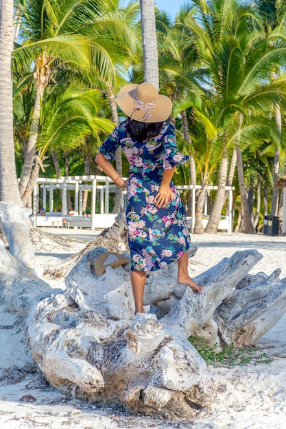 Dominican Republic of Punta Cana a girl in a hat on the ocean with turquoise water and palm trees