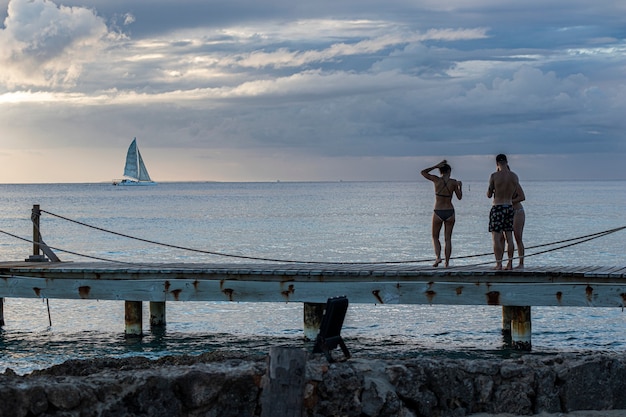 Dominican sunset on Pier with people watching the sea