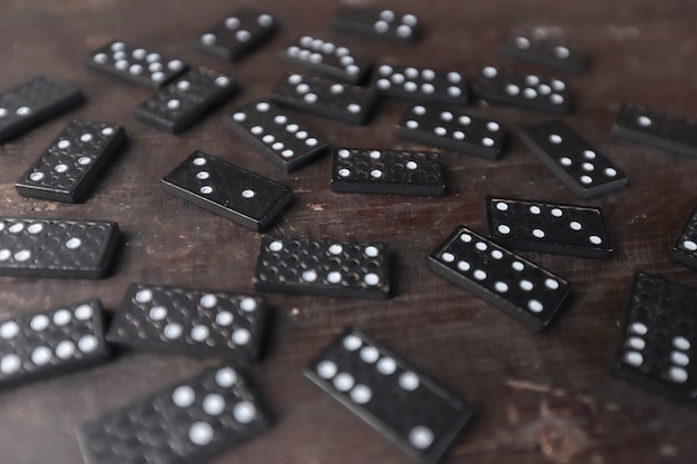 Domino game pieces scattered on old wood desk selective focus\
and perspective