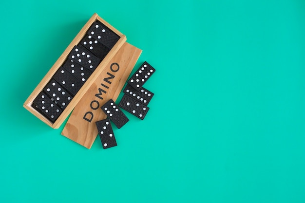 Photo domino game in wooden box on green background top view family board game