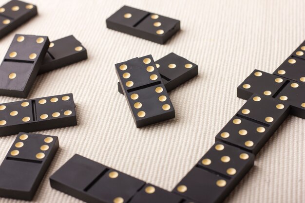 Domino pieces in black on a light table