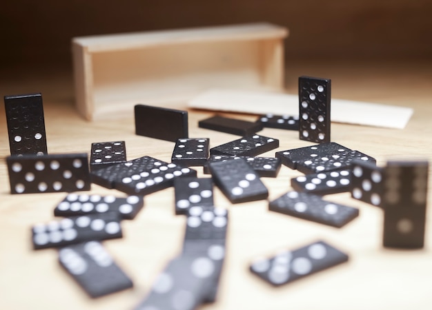 Domino speelstukken verspreid over houten bureau met houten kist