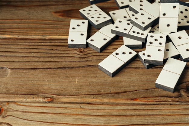 Domino tiles on wooden background close up