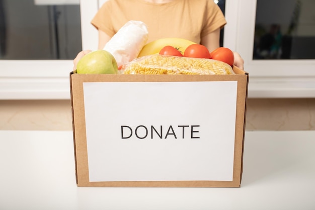 Donatie en liefdadigheid voor daklozen Vrouwenhanden houden een doos voedsel vast