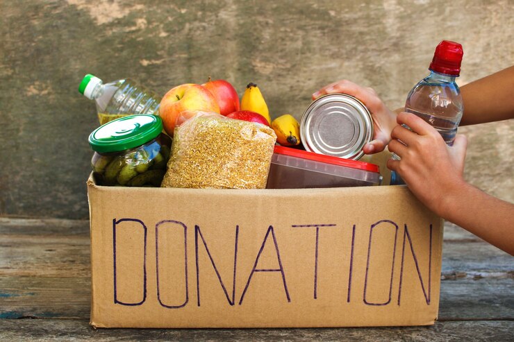 Donatiedoos met voedsel op oude houten achtergrond.