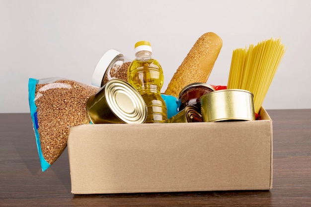 Scatola di donazione con cibo nelle mani di un volontario.