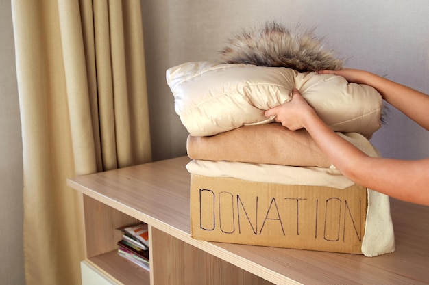 Donation box with winter clothes on the table