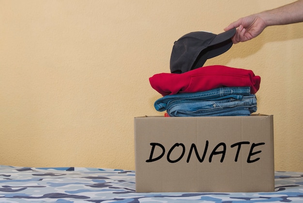 Donation Concept Man Preparing his Used Old Clothes into a Donate Box