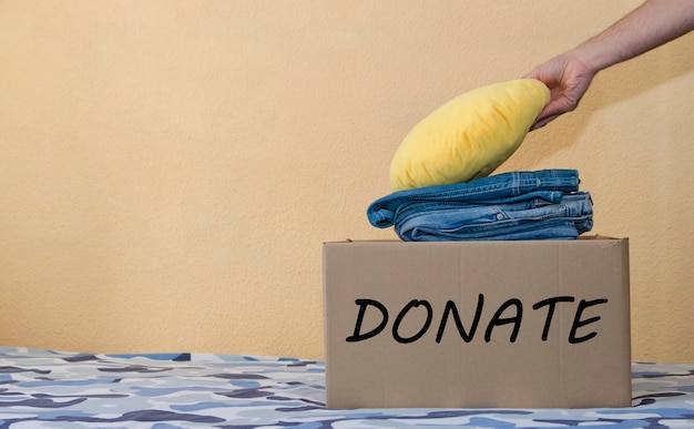 Donation Concept Man Preparing his Used Old Clothes into a Donate Box