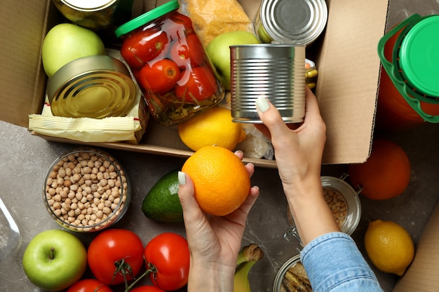 Foto concetto di donazione con mani femminili e cibo diverso