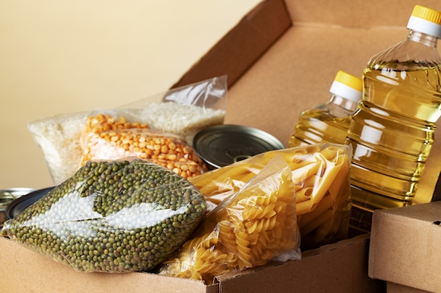Donazioni di cibo con cibo in scatola sullo sfondo della tabella. dona concetto. avvicinamento.