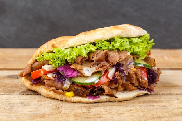 Foto doner kebab doner kebap fast food in focaccia su una tavola di legno