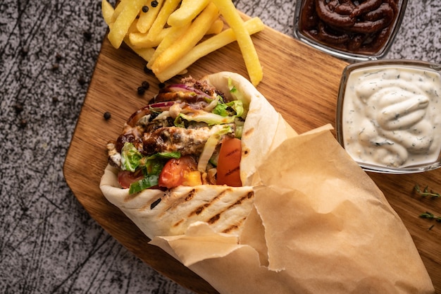 Doner kebab een shoarma in een pit van verse groenten en vlees met een groot kruidenrestaurant dat op...