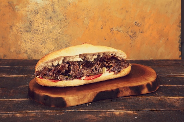 Doner kebab is lying on the cutting board Shawarma with meat onions salad lies on a dark old wood