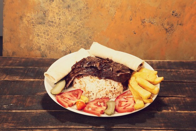 Doner 케밥은 도마에 누워 있다 Shawarma와 고기 양파 샐러드는 짙은 오래된 나무에 놓여 있다