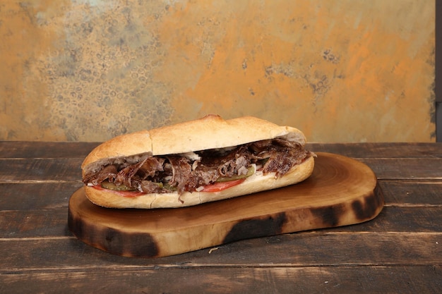 Photo doner kebab is lying on the cutting board shawarma with meat onions salad lies on a dark old wood