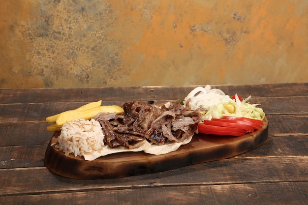Doner kebab ligt op de snijplank Shoarma met vleesuiensalade ligt op een donker oud hout