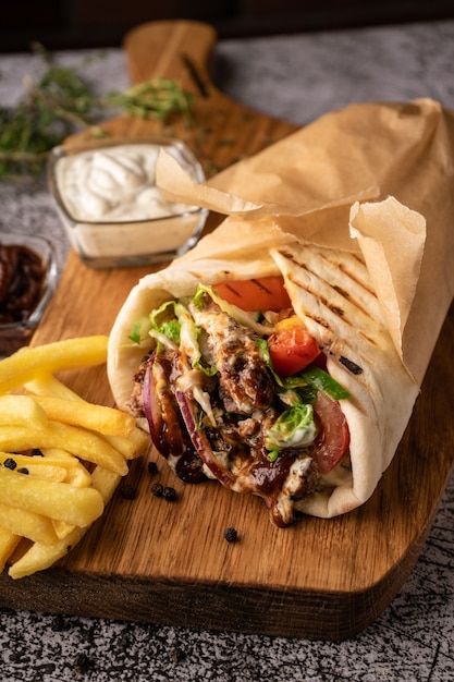 Doner kebab a shawarma in a pit of fresh vegetables and meat with large spices restaurant serving on...