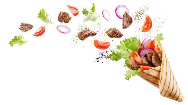Photo doner kebab or shawarma with ingredients floating in the air : beef meat, lettuce, onion, tomatoes, spice.