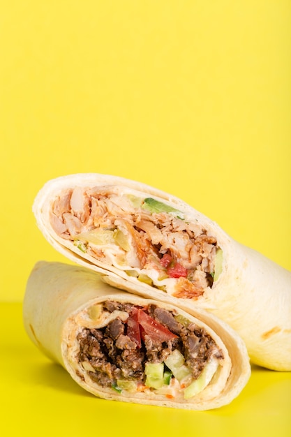 Doner roll shawarma with chicken and vegetables on yellow high quality photo