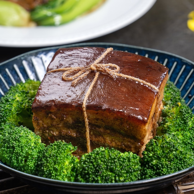 Dong po rou (dongpo-varkensvlees) in een mooi blauw bord met groene broccoligroente