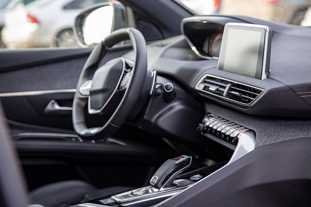 Donker luxe auto-interieur. Zwart lederen multifunctioneel stuur, start- en stopmotor, dashboard, stuur en bestuurdersstoel