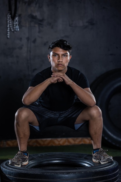 Foto donker portret van een mexicaanse tiener die zich concentreert op training in een crossfit gym.