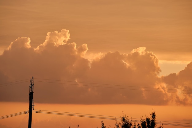 Donker silhouet van hoogspanningstorens met elektrische hoogspanningslijnen bij zonsopgang.