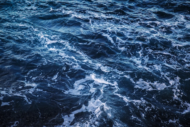 Donkerblauw zeewater met wit schuim bovenaanzicht