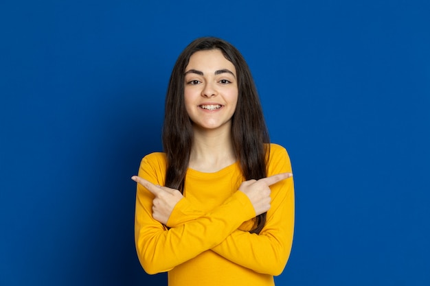 Donkerbruin jong meisje dat geel sweatshirt draagt