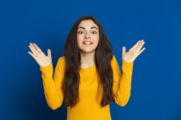 Donkerbruin jong meisje dat geel sweatshirt draagt