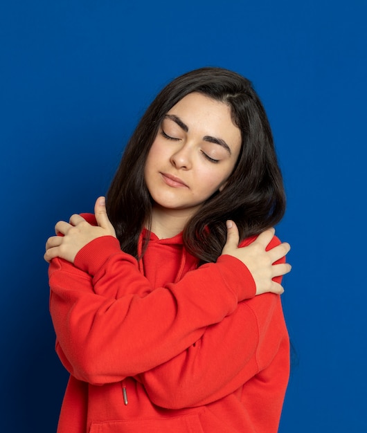 Donkerbruin jong meisje dat rood sweatshirt draagt