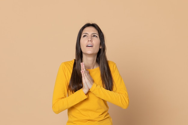 Donkerbruine jonge vrouw die een gele T-shirt draagt