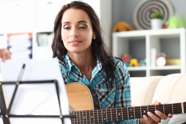 Donkerbruine vrouw die de gitaar speelt