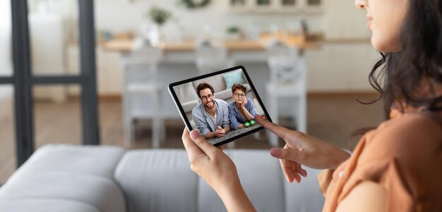 Donkerbruine vrouw die tablet gebruikt die haar familie belt