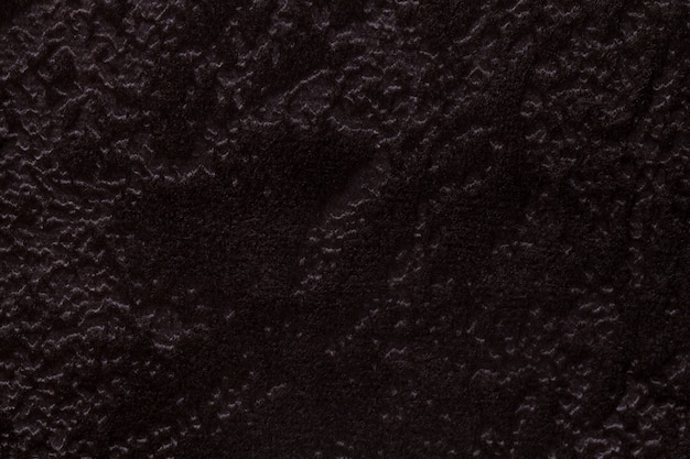 Donkere bruine achtergrond van een zacht stofferings textielproduct, close-up.