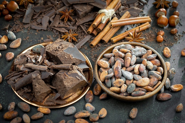 Donkere chocolade in een compositie met cacaobonen en noten, op een oude achtergrond.