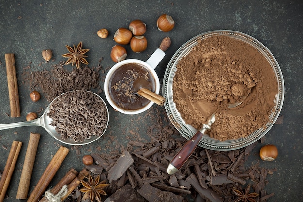 Donkere chocolade in een compositie met cacaobonen en noten, op een oude achtergrond.