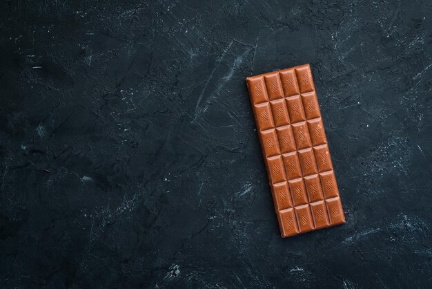 Donkere chocolade op een zwarte achtergrond Bovenaanzicht Gratis kopieerruimte