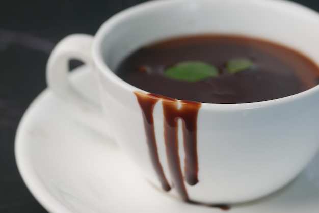 Donkere chocoladeroom in een koffiekopje op tafel