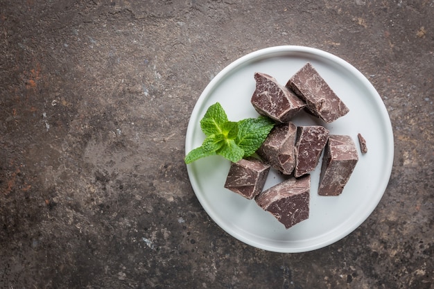 Donkere chocoladestukjes geplet op een donkere achtergrond, bovenaanzicht