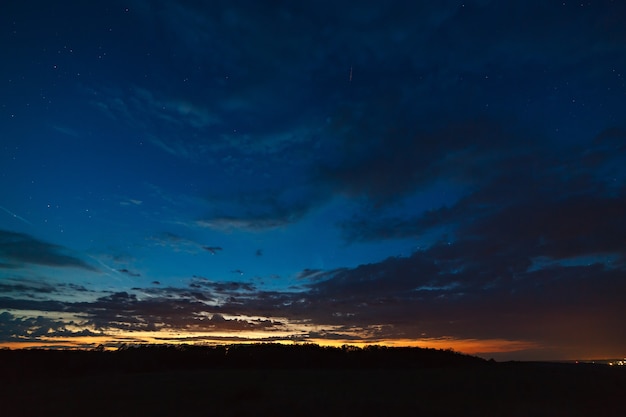 Donkere hemel met wolken na zonsondergang.