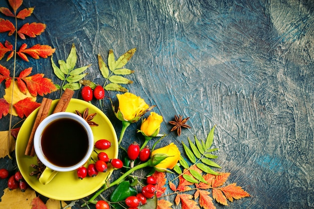 Foto donkere herfst achtergrond met kopje koffie en herfstbladeren.