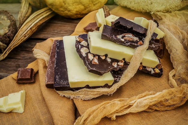 Donkere melk en witte chocoladerepen op houten achtergrond Bovenaanzicht met kopieerruimte